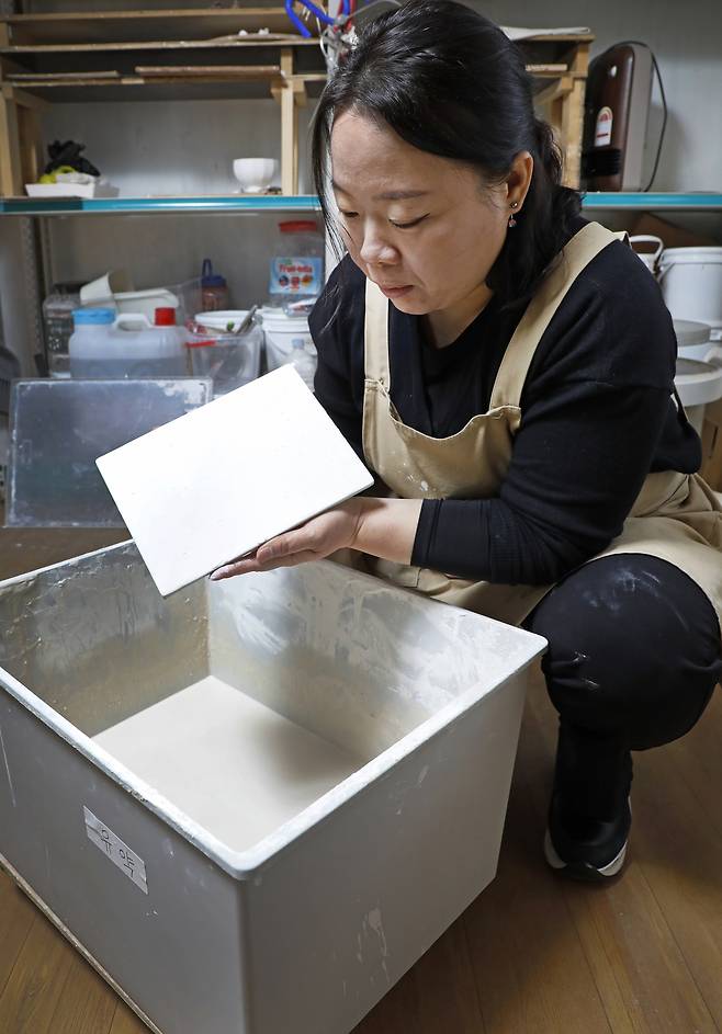 Kim Eun-kyung examines a painted porcelain slab. [PARK SANG-MOON]