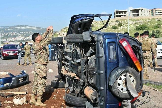 한 레바논 병사가 16일(현지시간) 남부 베이루트의 고속도로변에서 이스라엘 드론 공격에 당한 차량의 잔해를 정리하고 있다. AFP연합뉴스