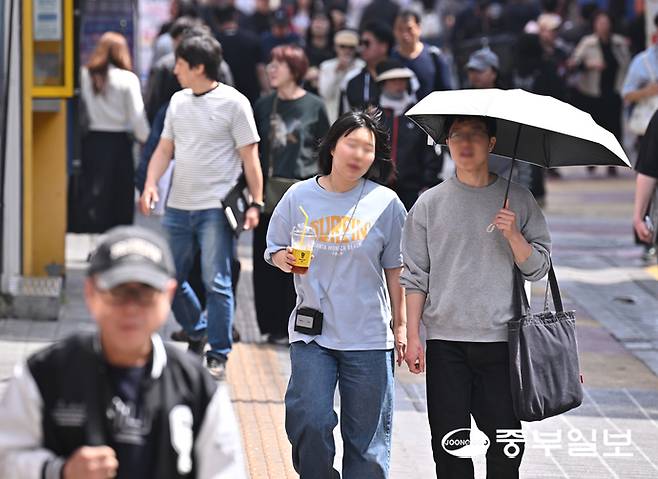 한낮 최고기온이 30도 가까이 오르며 초여름 날씨를 보인 19일 오전 수원역 로데오거리에서 시민들이 반팔 차림으로 발걸음을 옮기고 있다. 김경민기자