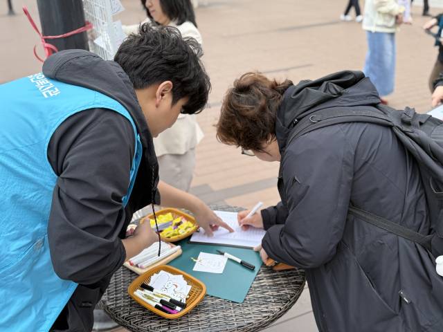 20일 장애인의 날을 맞아 부산 곳곳에서 기념식과 각종 행사가 열린다. 사진은 지난 14일 수영구 일대에서 진행된 장애 인식 개선 캠페인에서 시민들이 장애인들에게 응원 메시지를 적는 모습. 수영구청 제공
