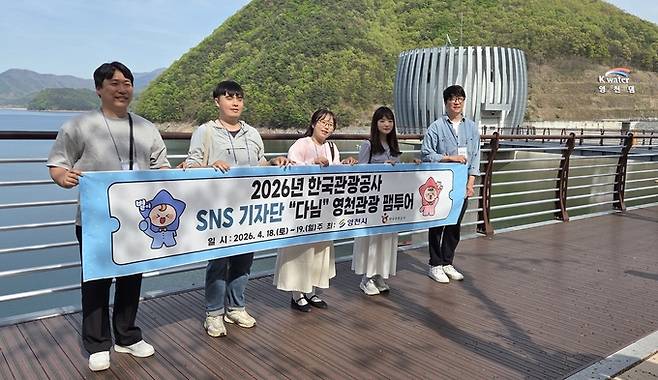 ▲ 한국관광공사SNS 기자단 '다님'이 18일 자양면 벚꽃 백리길 입구 영천댐에서 기념촬영을 하고 있다. 권오석 기자