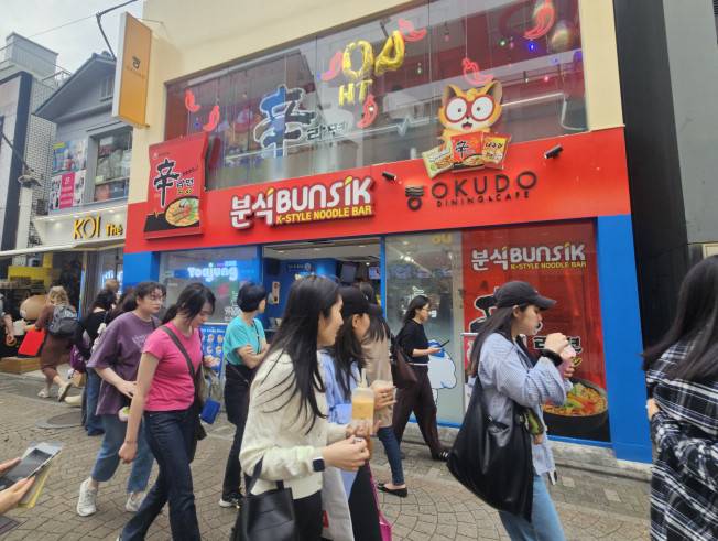 15일 도쿄 하라주쿠 다케시타 거리에 있는 '신라면분식' 외관을 일본인들이 신기한 듯 쳐다보며 지나가고 있다.(사진=정영인 기자 oin@)