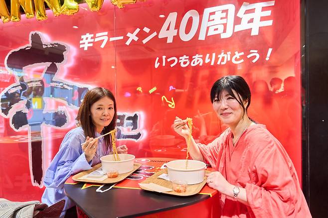 15일 도쿄 하라주쿠 다케시타 거리에 있는 '신라면분식' 방문객들이 일명 '한강 라면' 라면 즉석조리기를 체험한 뒤 라면을 맛보고 있다.(사진제공=농심)