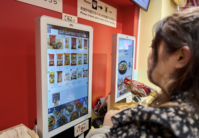 일본 도쿄 하라주쿠 다케시타 거리에 있는 ‘신라면분식’에서 방문객들이 키오스크로 한국 라면을 주문하고 있다. 농심 제공