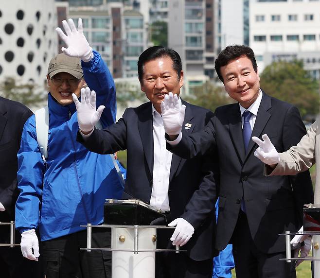 정청래(가운데) 더불어민주당 대표가 지난 18일 울산시 남구 태화강 둔치에서 열린 ‘울산 자전거 대축전’에서 전태진 변호사(오른쪽), 김상욱 울산시장 후보와 함께 참가자들에게 인사하고 있다. [연합]