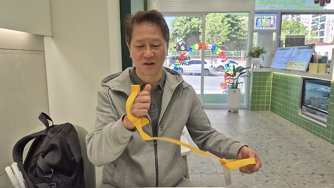 지난 15일 오후 대구 북구의 한 카페에서 시각장애인 임승호 씨가 러닝 시 가이드러너와 손목을 연결해 달리는 트러스트 스트링에 대해 설명하고 있다. 조윤화 기자