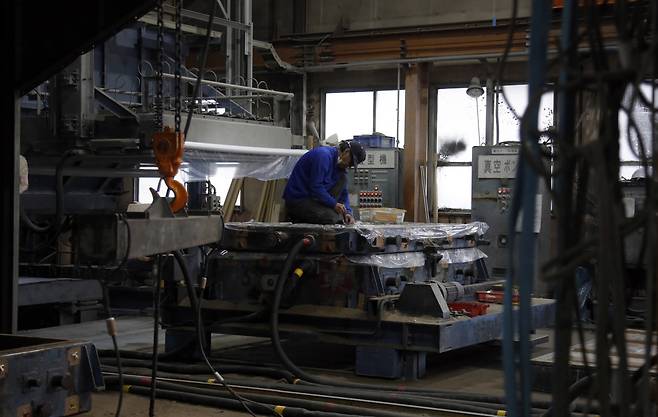 일본 도쿄도 하치오지시에 있는 사카에캐스팅 공장에서 근로자가 배터리와 반도체 냉각에 쓰는 알루미늄 부품을 생산하고 있다. (하치오지(일본)/AP뉴시스)
