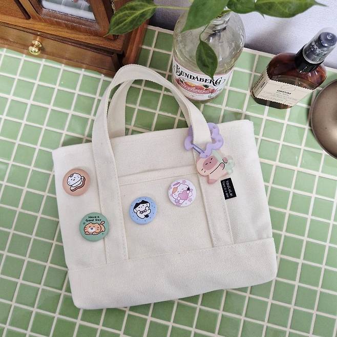 뱃지와 카라비너형 키링으로 꾸민 가방.(리틀영(littleyoung) 작가)