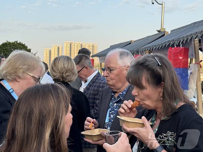 치킨을 맛보고 있는 버츄오소 측 참가자들의 모습ⓒ 뉴스1 윤슬빈 관광전문기자