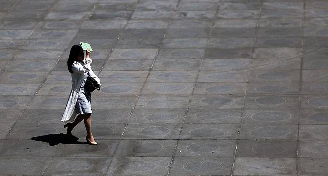 서울 낮 최고기온이 29도를 기록하며 초여름 날씨를 보인 19일 서울 종로구 광화문광장에서 한 시민이 햇볕을 가리며 길을 걷고 있다. 뉴시스