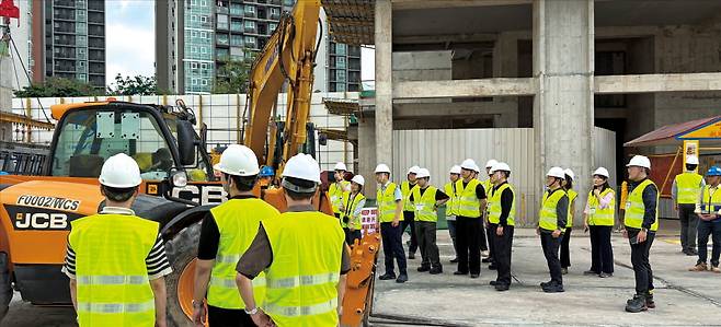 한국경영자총협회 시찰단이 지난 2일 싱가포르 고급 주거지역인 탕린 주변의 한 아파트 건설 현장을 둘러보고 있다. 이 현장에서 쓰이는 중장비에는 근접 센서가 부착돼 있다. 작은 사진은 현장 관계자가 안전 시스템을 설명하는 모습.  양길성 기자