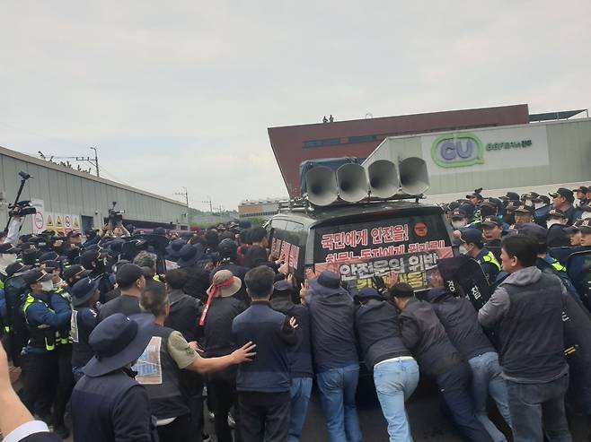 20일 오후 경남 진주시 정촌면 BGF로지스 진주센터에서 화물연대 관계자가 센터 진입을 시도하는 과정에서 경찰과 대치하고 있다. /연합뉴스