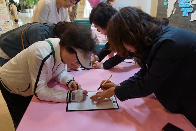 해운대신일교회 ‘뉴패밀리 초청 축제’에 초대된 태신자들이 참석자 명단에 이름을 기입하고 있다.