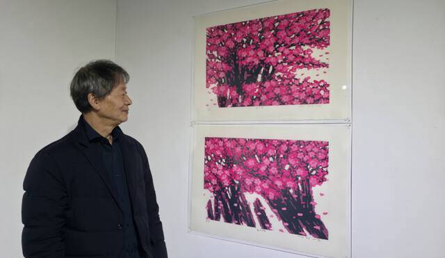 김억 작가가 자신의 작품 ‘홍매’ 시리즈를 들여다보고 있다. 이나경기자