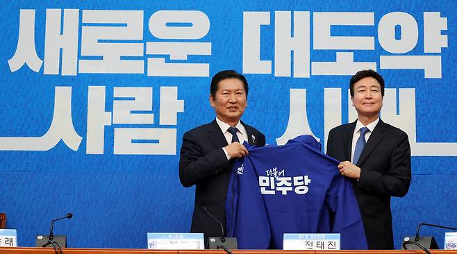 정청래 더불어민주당 대표(왼쪽)와 전태진 변호사가 4월17일 국회에서 열린 1차 인재영입식에서 파란색 당 점퍼를 들고 기념촬영을 하고 있다. ⓒ연합뉴스