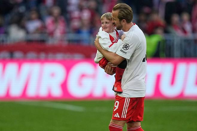 해리 케인이 20일 독일 뮌헨 알리안츠 아레나에서 열린 슈투트가르트와의 분데스리가 경기 후 리그 우승을 확정한 뒤 아들을 안고 기쁨을 나누고 있다. AP