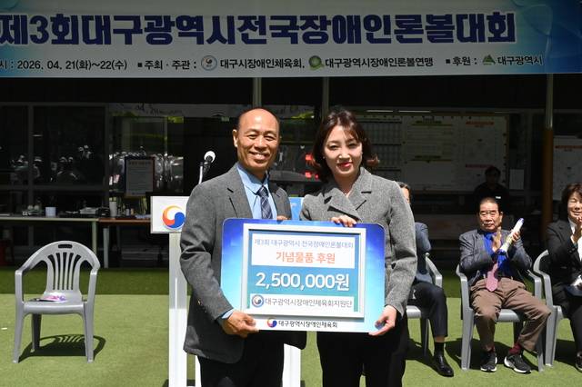 전국 최초 장애인체육 후원조직인 지원단의 이경숙 부단장(오른쪽)이 개회식에서 후원물품 전달 증서를 전달하고 있다. 대구광역시장애인체육회 제공