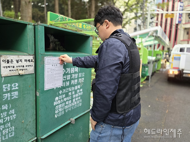 클리하우스 옆에 무단으로 설치된 의류수거함에 계고장이 부착되고 있다.