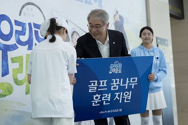 임종률 우리금융그룹 회장이 21일 열린 우리금융 드림라운드에 참가한 학생에게 훈련지원금을 전달하고 있다.