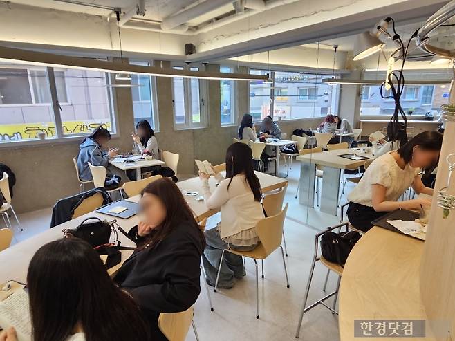 지난 14일 오후 5시경 서울 송파구 송리단길에 위치한 카페 '하우피'에서 2030 고객들이 도파민 텍스트 콘텐츠를 읽어보고 있다. /사진=박수빈 기자