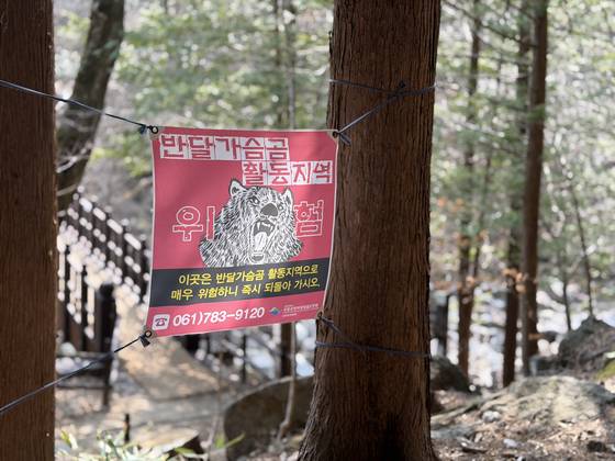 A warning sign about Asiatic black bears hangs along a trail in Jirisan National Park. [CHON KWON-PIL]