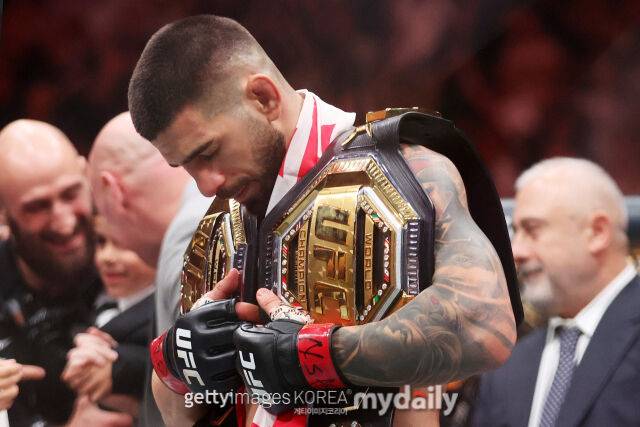 토푸리아가 지난해 6월 올리베이라를 꺾은 후 UFC 챔피언 벨트 두 개를 허리에 메고 세리머니 하고 있다. /게티이미지코리아