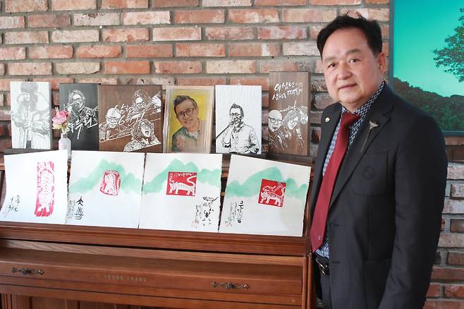 판화를 배경으로 포즈 취한 에드워드 손 대표 (서울=연합뉴스) 박현수 기자 = 지난 10일 서울 종로구 삼청동 한 카페에서 판화를 배경으로 포즈를 취한 에드워드 손 '팀 스피릿 그룹' 대표. 그는 "민화와 판화 같은 한국의 전통 예술품이 향후 K-팝과 K-드라마의 열풍을 이어갈 것"이라고 말했다. 2026. 4.10 phyeonsoo@yna.co.kr