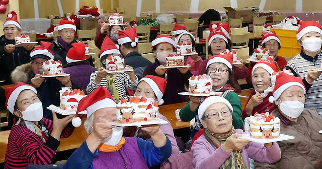 ▲ 지난해 12월16일 인천 동구 창영종합복지관에서 열린 '어르신 성탄 축제'에 참가한 어르신들이 직접 만든 케이크를 들고 기념촬영을 하고 있다. /인천일보 DB