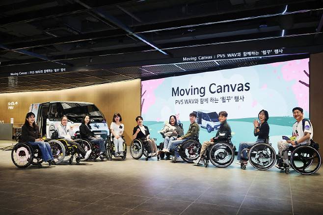 20일 오후 휠체어 꾸미기를 마친 참석자들이 PV5 WAV 차량 앞에서 기념사진을 촬영하고 있다. PV5 WAV는 휠체어 이용자의 편리하고 안전한 이동을 위해 개발된 차량이다. (사진= 기아)