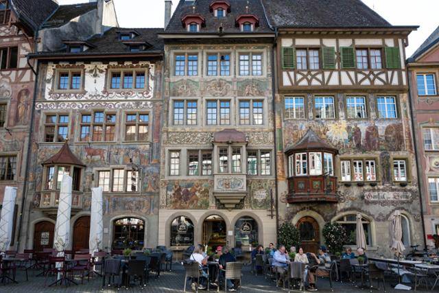 샤프하우젠주 슈타인 암 라인 시청 광장의 벽화 건물 앞에서 시민들이 여유를 즐기고 있다.