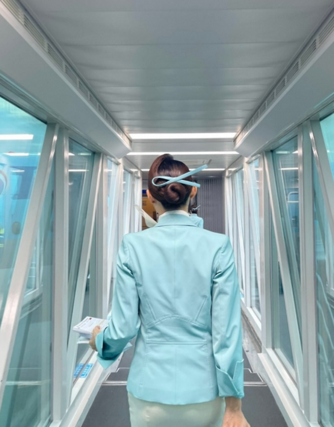 대한항공 객실 승무원이 탑승 게이트로 향하고 있다. 유니폼과 복장 규정은 오랫동안 항공사의 서비스 이미지를 상징해 왔다. (대한항공 SNS)