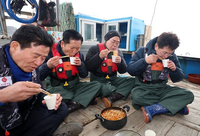 정청래 더불어민주당 대표와 박찬대 민주당 인천시장 후보가 지난달 11일 인천 강화군 서검도 앞바다 조업한계선 근처 괴리어장에서 새우잡이 조업 현장 체험을 하며 간식을 먹고 있다. 연합뉴스