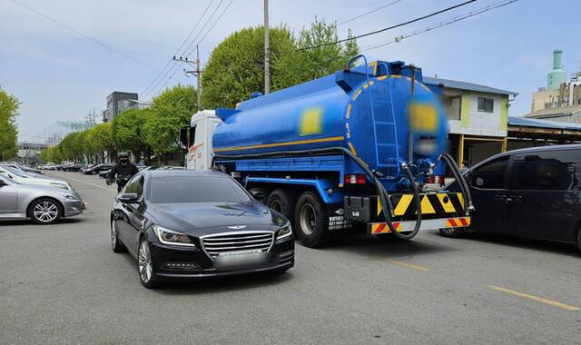21일 인천 서구 한 공업지역. 불법주차 차량을 피해 탱크차가 중앙선을 밟고 지나자 맞은편 승용차가 비켜서고 있다. 박기웅기자