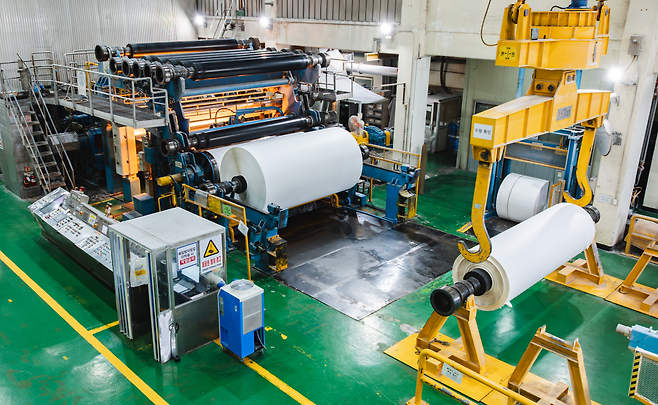 한솔제지 천안공장의 백판지 생산시설(왼쪽)과 한솔제지가 멸균팩을 재활용해 만든 달력·거치대 세트.  [한솔제지 제공]