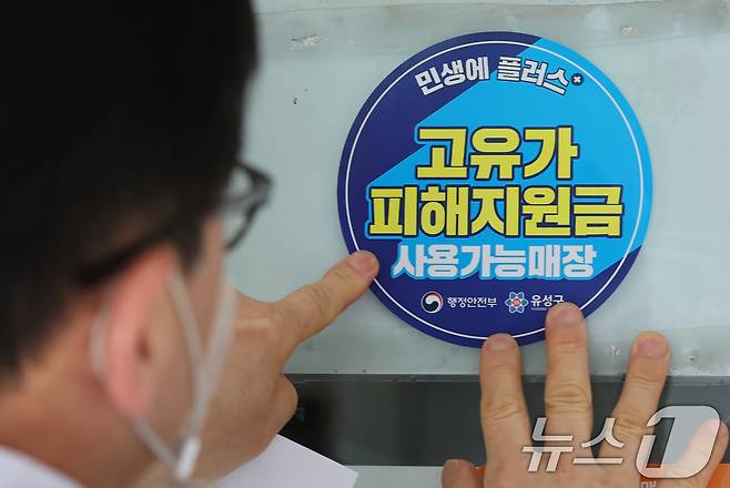 고유가 피해지원금 신청을 앞두고 23일 대전 유성구 한 식당 주인이 피해지원금 사용가능매장 안내문을 붙이고 있다. 2026.4.23 ⓒ 뉴스1 김기태 기자