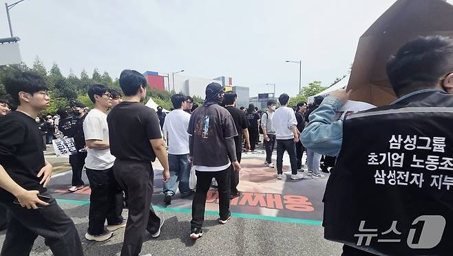 23일 경기 평택시 고덕동 삼성전자 평택캠퍼스에서 열린 삼성전자 노동조합 공동투쟁본부 '4·23 투쟁 결의대회'에서 이재용 삼성전자 회장, 전영현 삼성전자 대표이사 부회장, 노태문 삼성전자 사장의 사진을 밟고 지나가고 있다. 2026.4.23 ⓒ 뉴스1 박기범 기자