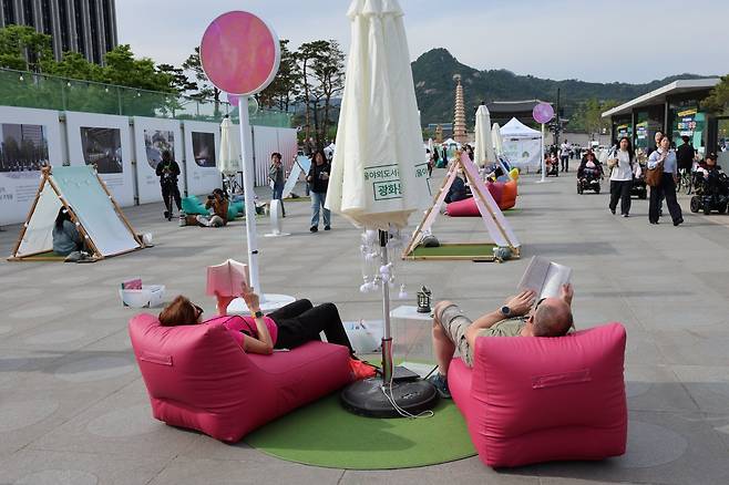 서울야외도서관 운영이 시작된 23일 오후 서울 종로구 광화문광장에 마련된 ‘광화문 책마당’에서 외국인 관광객들이 책을 읽고 있다. 2026.4.23 (서울=뉴스1)