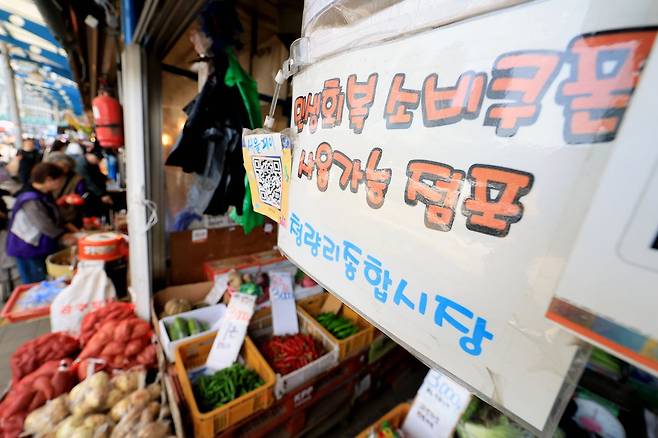 정부가 중동 사태 장기화로 인한 고유가 피해 지원금을 70%의 국민에게 1인당 10만 원에서 최대 60만 원까지 오는 27일부터 차등 지급한다. 사진은 14일 서울 동대문구 경동시장 한 점포에 '민생회복 소비쿠폰 사용 가능' 안내문이 걸려있는 모습. [뉴스1]