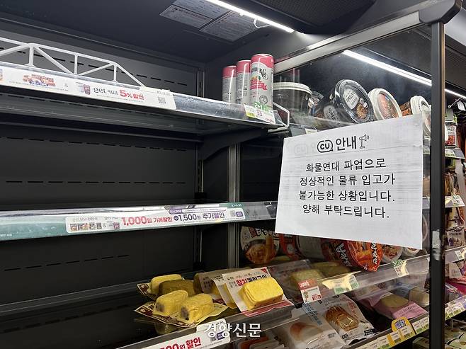 21일 오전 서울 마포구 홍대입구역 인근의 한 CU 매장 매대 옆에 ‘화물연대 파업으로 간편식 공장이 폐쇄돼 정상적인 물류 입고가 불가능하다’는 내용의 안내문이 붙어있다. 하주언 기자