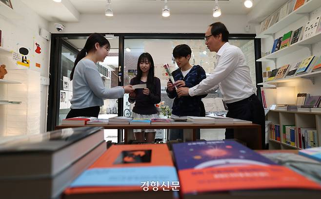 ‘세계 책의 날’인 23일 서울 마포구 독립서점 테일탱고에서 김아영 대표와 홍영완 한국출판인회의 회장이 고객들에게 꽃과 책을 건네고 있다.