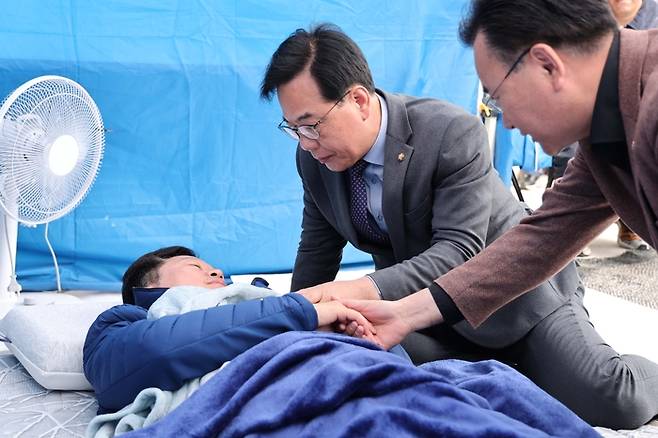 국민의힘 송언석 원내대표와 유상범 원내운영수석부대표가 22일 국회 본청 앞에서 단식 12일 차를 맞은 안호영 의원의 천막 농성장을 찾아 대화하고 있다. [공동취재]