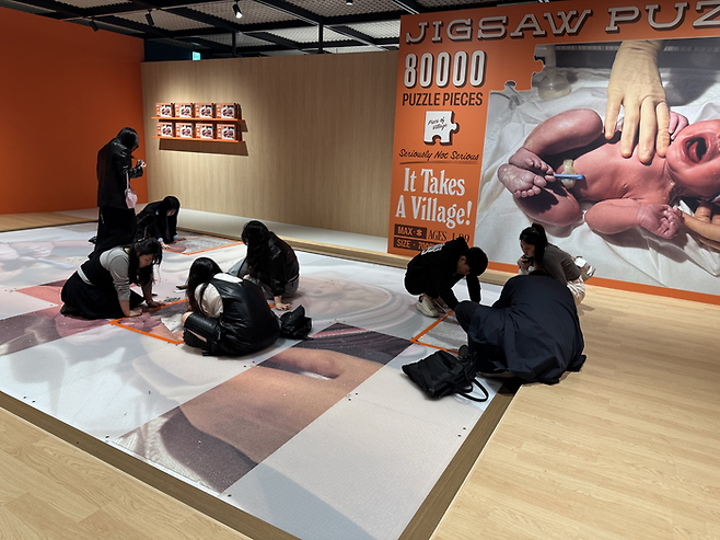 20일 서울 중구 그라운드시소 센트럴에서 맥스 시덴토프 개인전을 방문한 관객들이 퍼즐을 맞추고 있다. <정유정 기자>