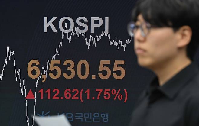 코스피가 미국 기술주 훈풍과 SK하이닉스의 역대 최대 실적을 소화하며 사상 처음 6500선을 돌파한 가운데  23일 오전 서울 여의도 Kb국민은행 딜링룸에서 직원들이 업무를 보고 있다. 이상섭 기자
