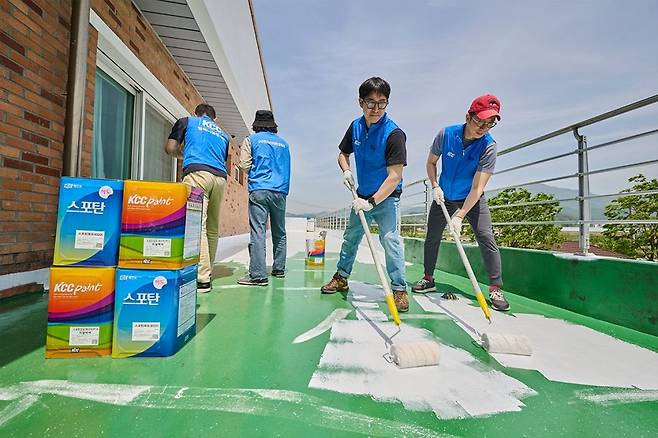 직원들이 옥상에 KCC의 백색 차열 페인트 스포탄 상도를 바르고 있다. 이 소재에는 열기 축적을 줄이는 쿨루프 공법이 도입됐다. [KCC 제공]