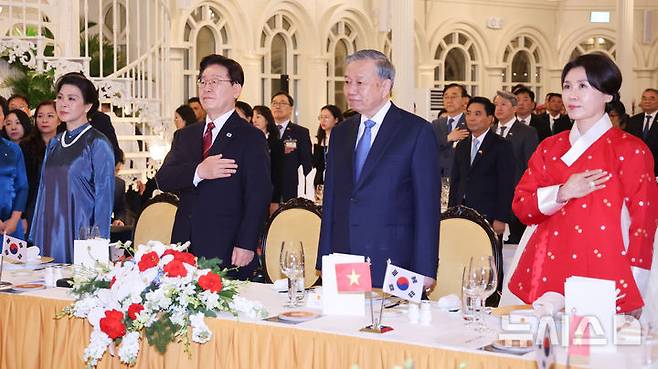 [하노이=뉴시스] 고범준 기자 = 이재명 대통령과 김혜경 여사, 또 럼 베트남 당 서기장 겸 국가주석과 응오 프엉 리 여사가 22일(현지 시간) 베트남 하노이 영빈관에서 열린 국빈만찬에서 국민의례를 하고 있다. 2026.04.23. bjko@newsis.com