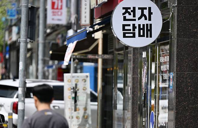 [광주=뉴시스] 박기웅 기자 = 합성니코틴 액상에 세금을 부과하는 담배사업법 개정안 시행을 하루 앞둔 23일 오후 한 시민이 광주 광산구 전자담배 판매업소 앞을 지나가고 있다. 2026.04.23. pboxer@newsis.com *재판매 및 DB 금지