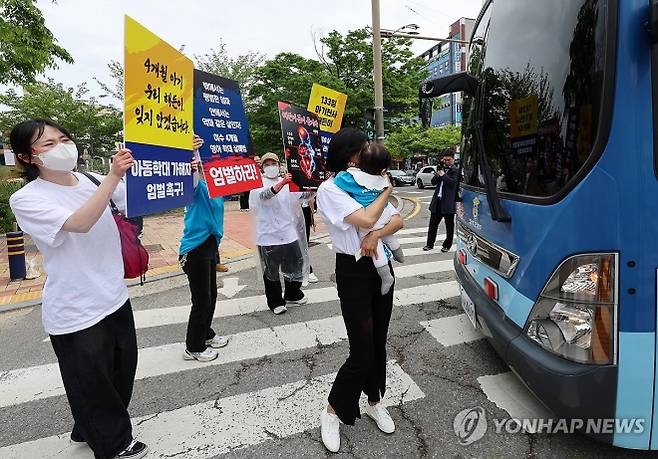 광주지법 순천지원에서 해든이 추모 및 아동학대 근절·법 개정 촉구 집회 참가자들이 생후 4개월 아들을 학대해 숨지게 한 부부가 탄 호송차를 가로막고 있다. 연합뉴스.