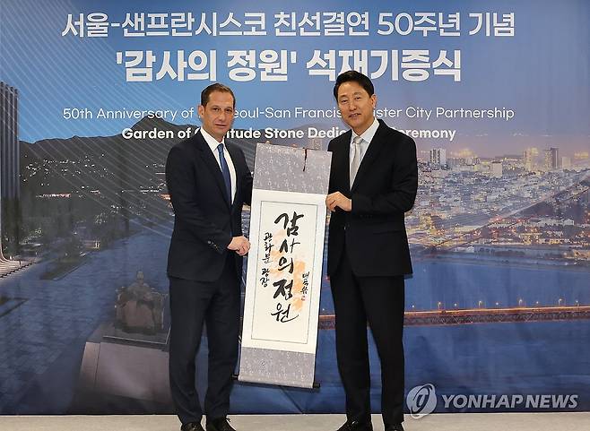감사선물 전하는 오세훈 서울시장 (서울=연합뉴스) 최재구 기자 =오세훈 서울시장이 23일 서울시청에서 열린 서울-샌프란시스코 친선결연 50주년 기념 '감사의 정원' 석재기증식에서 대니얼 루리 샌프란시스코 시장에게 족자를 선물로 전달하고 있다. 2026.4.23 jjaeck9@yna.co.kr