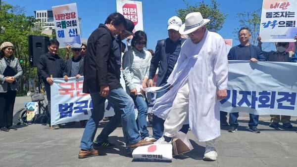 24일 서울 광화문광장에서 열린 국민의힘 해산청구 범국민서명운동 선포식에 참여한 시민사회단체 대표들이 국민의힘 해산 사유가 기재된 상징물을 발로 밟아 응징하는 퍼포먼스를 벌이고 있다.&nbsp;전국시국회의 제공