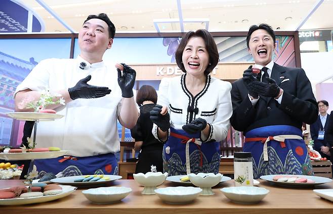 이재명 대통령과 베트남을 국빈 방문 중인 김혜경 여사가 23일 하노이 롯데몰에서 열린 K문화관광대전에서 배우 정일우, 지준혁 셰프와 마카롱을 만들고 있다. /뉴스1